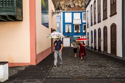 Personas con paraguas se protegen de la lluvia de ceniza en Santa Cruz de La Palma.