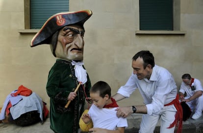 Un ni&ntilde;o trata de evitar ser golpeado por un cabezudo en Pamplona durante las fiestas de San Ferm&iacute;n.