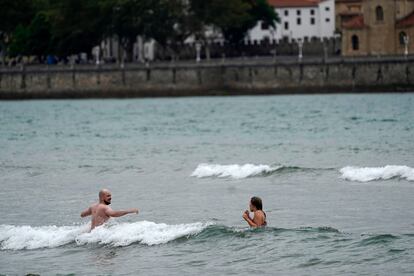 Dos aguerridos bañistas en la playa de San Lorenzo de Gijón, este domingo.