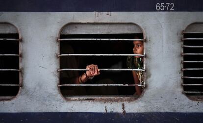 Una niña mira desde el interior de un tren parado por la falta de electricidad.