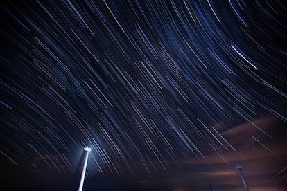 Una turbina eólica se ve bajo el cielo estrellado sobre la montaña Kuocang en Taizhou, provincia de Zhejiang, China, el 19 de julio de 2017.