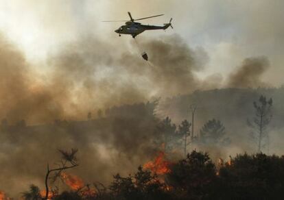 Un helicóptero descarga agua sobre el incendio de A Fonsagrada (