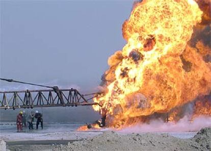 Bomberos tratan de controlar el fuego en un pozo de crudo iraquí.