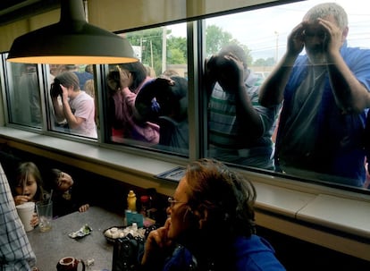 Un grupo de gente se asoma por las ventanas para echar un vistazo a la candidata presidencial demócrata Hillary Clinton durante un acto de campaña en el restaurante La Gala, el16 de de mayo de 2016, en Bowling Green, Kentucky.