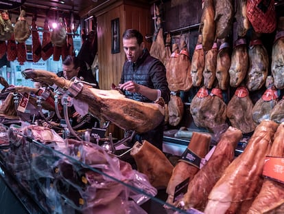 Un empleado corta jamón en una charcutería de Valencia.