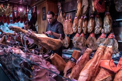 Un empleado corta jamón en una charcutería de Valencia.