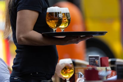 A waitress serves alcoholic drinks on a terrace in Berlin on August 9.