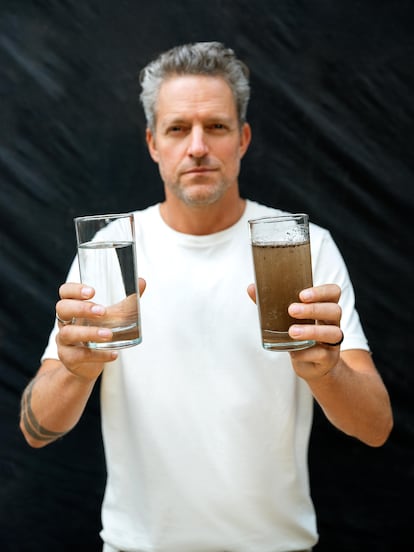 Jon Rose sosteniendo un vaso de agua sucia y el resultados después de potabilizarla.