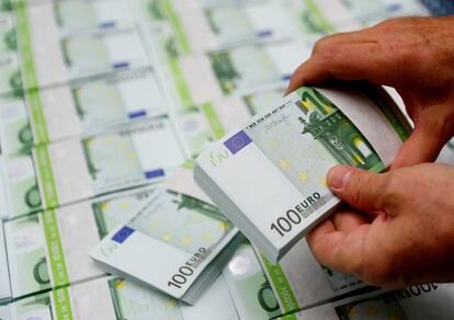 Un empleado de una empresa austriaca revisa billetes de 100 euros en Viena.