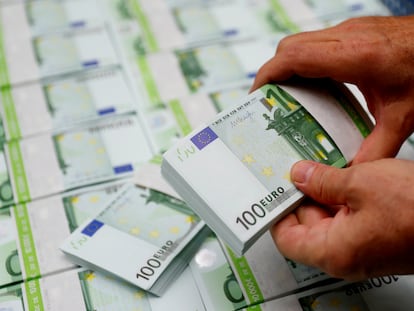 Un empleado de una empresa austriaca revisa billetes de 100 euros en Viena.