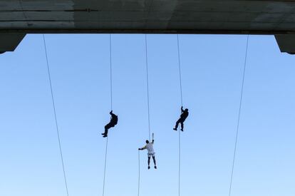 El policia militar portador de la antorcha Manoel Costa desciende desde el puente Juscelino Kubitschek en Brasilia.