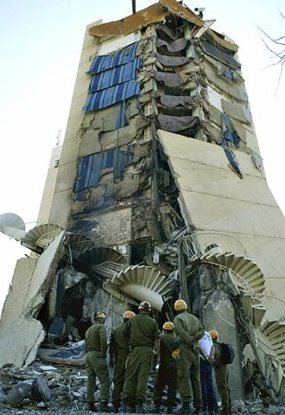 Un equipo de rescate contempla la fachada destruida del Hilton de Taba.