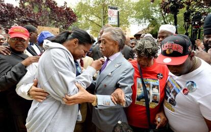 El Reverendo Al Sharpton consuela a la mujer y familiares de Eric Garner, muerto a manos de la policía cuando era detenido en Nueva York.