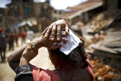 Una mujer se tapa la herida en la cabeza tras el terremoto en la ciudad de Sankhu (Nepal).