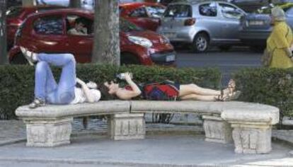 Dos turistas descansan en la zona del Museo de Ciencias Naturales de Madrid. EFE/Archivo