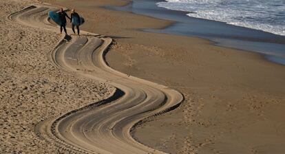 Unos surfistas caminan este jueves por la playa de la Zurriola de San Sebastián (Gipuzkoa).