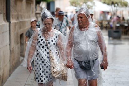 Dos personas se protegen de la lluvia, el jueves en Valencia. 