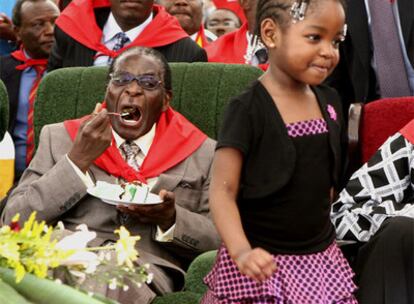 El presidente de Zimbabue, ataviado con el tradicional pañuelo rojo de su partido, come un trozo de tarta durante su 85 aniversario.