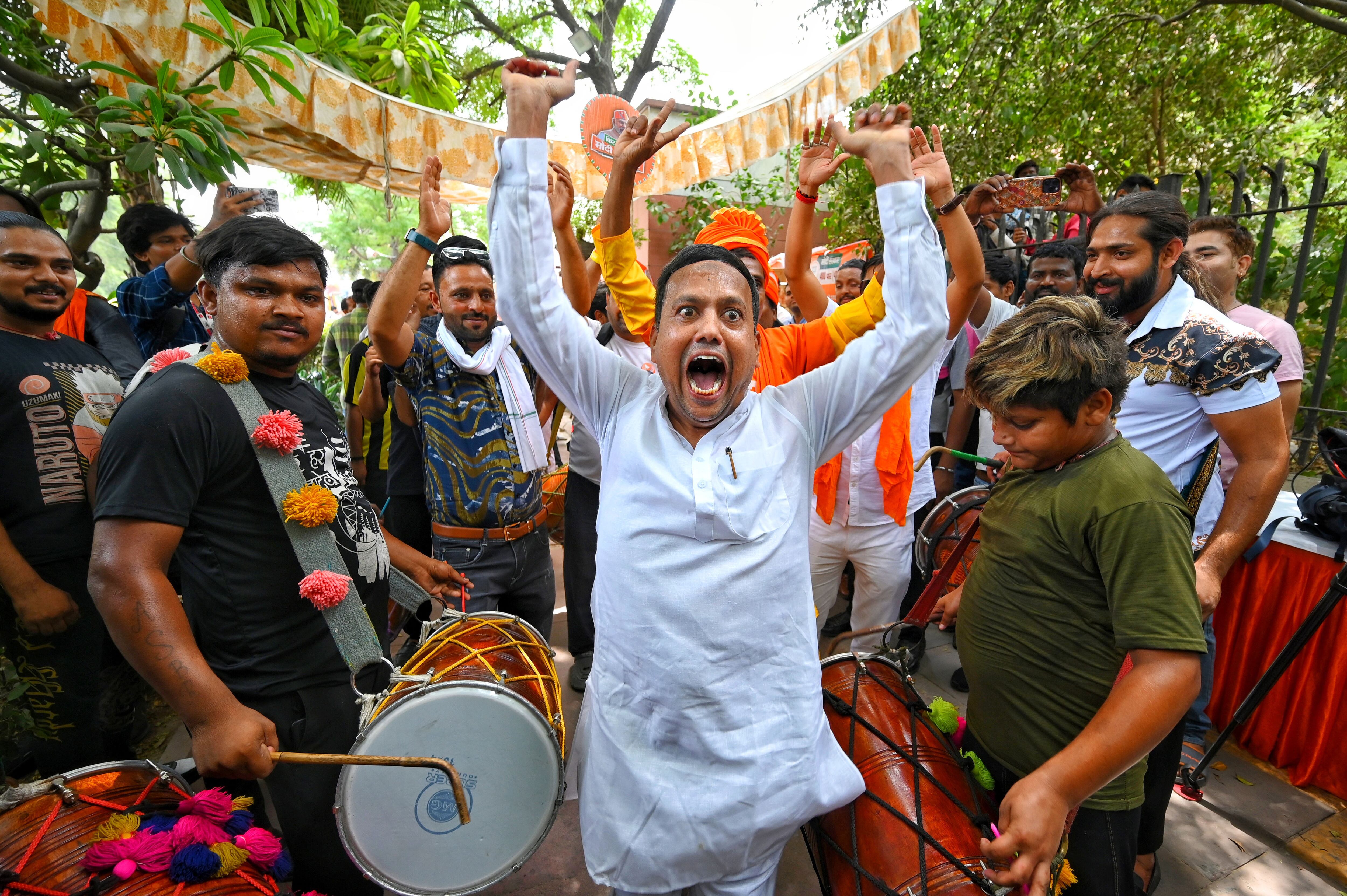 Varias personas festejan los primeros resultados del escrutinio de las elecciones en la sede del BJP, este martes en  Nueva Delhi.