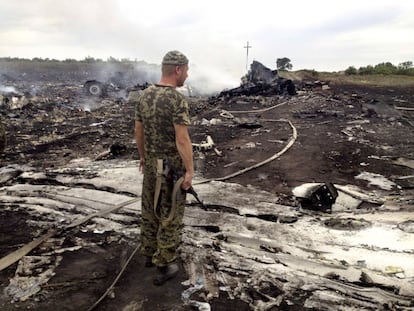 Um rebelde pró-russo observa os destroços do avião de Malaysia Airlines.