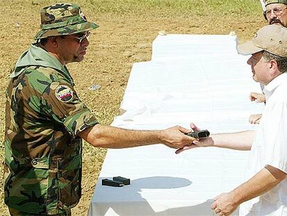 Salvatore Mancuso, jefe de los paramilitares de Colombia, entrega su arma ayer al comisionado de paz.