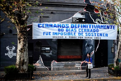 Um comércio fechado durante a pandemia em Buenos Aires exibe uma faixa de protesto na fachada.