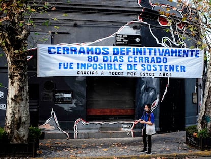 Um comércio fechado durante a pandemia em Buenos Aires exibe uma faixa de protesto na fachada.