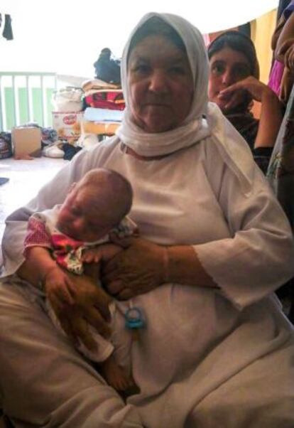 La abuela Gharib sostiene a Hyden en un colegio que acoge a familias desplazadas en Zakho, norte de Irak.