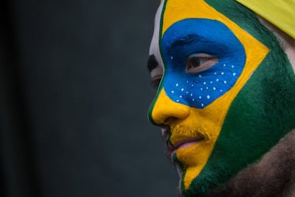 Un hombre con el rostro pintado con la bandera de Brasil avanza con los manifestantes contra el gobierno a lo largo de la Avenida Paulista.