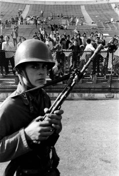 Un soldado chileno hace guardia frente a los prisioneros, en el estadio Nacional de Chile tras el golpe de Estado de Pinochet, en 1973. / reuters