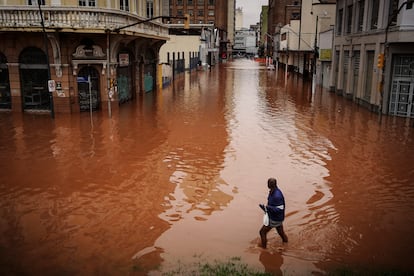 Un hombre camina por una calle inundada debido a las intensas lluvias, el viernes 3 de mayo de 2024, en Porto Alegre.