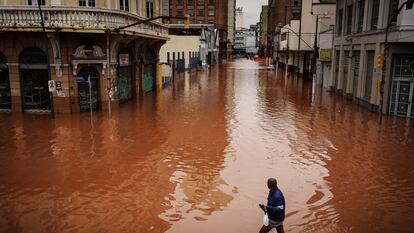 Un hombre camina por una calle inundada debido a las intensas lluvias, el viernes 3 de mayo de 2024, en Porto Alegre.