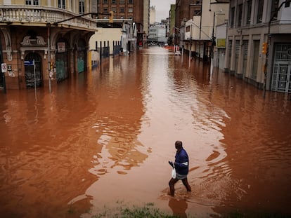 Un hombre camina por una calle inundada debido a las intensas lluvias, el viernes 3 de mayo de 2024, en Porto Alegre.