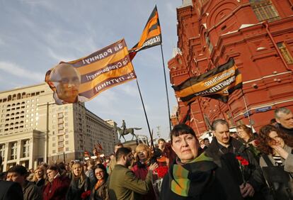 Varias personas portan banderas con la imagen del presidente Putin en la manifestación.