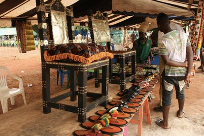 Los artesanos aprovechan la afluencia de gente para vender productos tradicionales de los brong. en la imagen, un puesto de venta de sillas -que simbolizan el poder de los jefes- y las características sandalias de su atuendo.