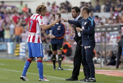 Forlán recibe agua de Jordi García mientras Quique Sánchez Flores, entrenador del Atlético le da instruciones en la tercera jornada de la Liga de Primera División en el estadio Vicente Calderón. Atlético de Madrid 1- Barcelona 2. (19/09/2010)