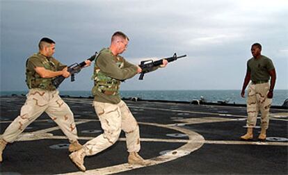 Los <b><i>marines</b></i> estadounidenses Angel Salcedo y Johnny Piles entrenan en la cubierta del buque <b><i>USS</b></i> <b><i>Austin,</b></i> en aguas del Golfo Pérsico.