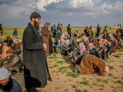 Supuestos miembros del autodenominado Estado Islámico esperan a ser registrados por fuerzas kurdas tras salir de Baguz, el último reducto del califato al este de Siria.