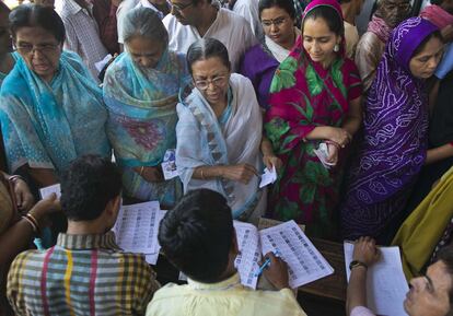 Votantes comprueban sus nombres antes de votar en Varanasi (India).