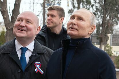 This handout photograph taken and released by the Russian presidential press office in Sevastopol on March 18, 2023, shows Russian President Vladimir Putin (R), talking to Sevastopol Governor Mikhail Razvozhayev (L), as he visits the Chersonesos Taurica historical and archeological park on the 9th anniversary of the referendum on the state status of Crimea and Sevastopol and its reunification with Russia.