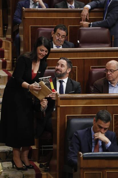 La diputada de Vox Macarena Olona entrega el libro de Fernando Sánchez Dragó, 'Santiago Abascal. España vertebrada', al presidente de Vox.