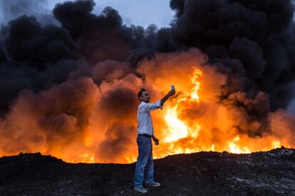 Un hombre se saca un selfi frente al fuego resultante de un incendio provocado por el Estado Islámico en un pozo de petróleo en Qayyarah (Irak), el 19 de octubre de 2016.