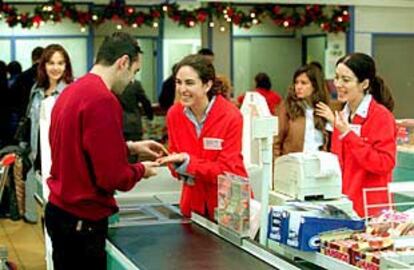 Un cliente de un centro comercial de San Sebastián de los Reyes (Madrid) comprueba el cambio en euros de sus compras.