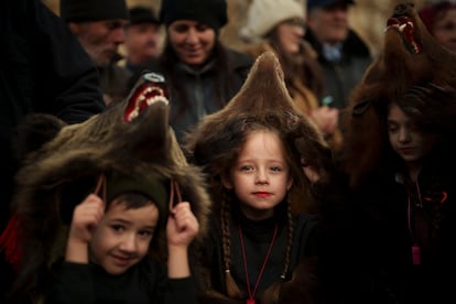 Sofia, 6 years-old, center, a members of a traditional bear pack takes part in a parade before performing in a festival in Moinesti, northern Romania, Wednesday, Dec. 27, 2023.