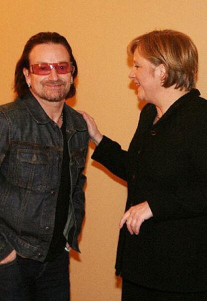 La canciller alemana Angela Merkel charla con Bono, cantante del grupo irlandés U2. Merkel ha aprovechado el discurso de apertura para lanzar un mensaje de optimismo en el futuro de Europa; un continente que debería ser "el más dinámico del mundo" para 2010.