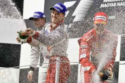 Kimi Raikkonen y Michael Schumacher, a la derecha, celebran con champaña sus dos primeros puestos en el podio.
