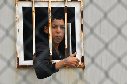Un joven se asoma a la ventana de una casa prefabricada en el campamento de Piniers en Ceuta, el 20 de mayo.