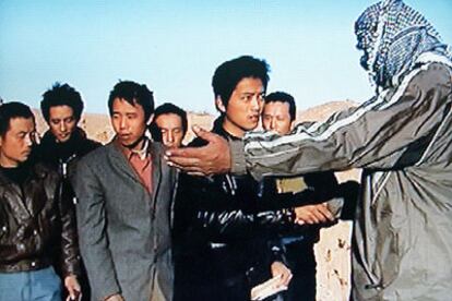 Un secuestrado chino estrecha la mano de uno de sus captores tras ser liberado con el resto de sus compañeros.