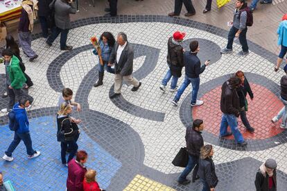 Viandantes paseando por el mosaico de Joan Miró en La Rambla (Barcelona).