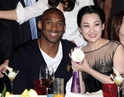 Kobe Bryant le presta la medalla de oro de Londres 2012 a la actriz china Xu Qing en un acto de recaudaci&oacute;n de fondos.